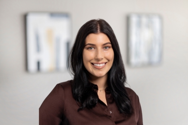 Causcasian female with brown long hair wearing a brown shirt